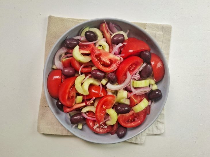 Tigela grande com os ingredientes picados e as azeitonas misturados.