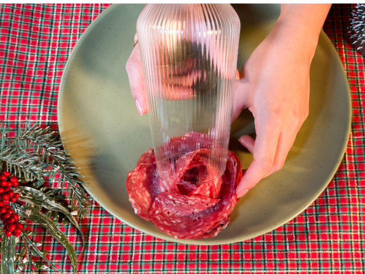 Fatias de salame sendo moldadas na borda de copo, formando a flor.