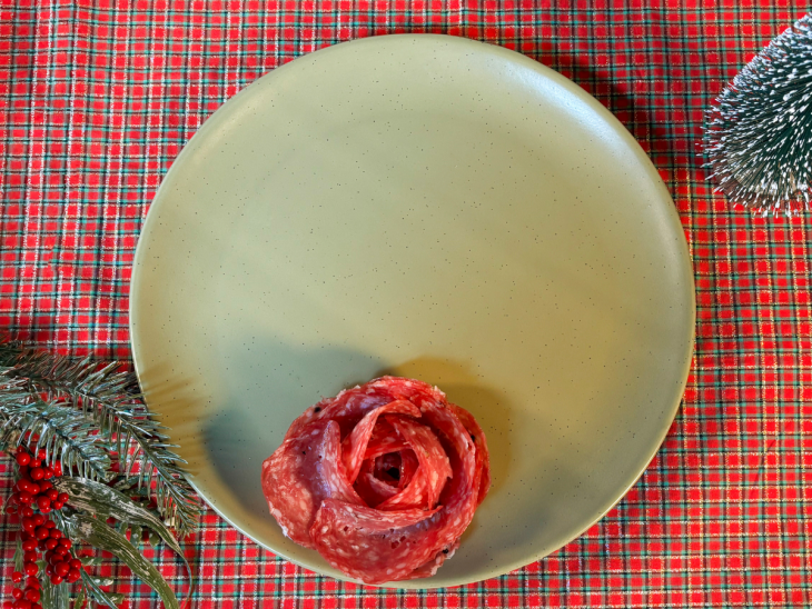 Flor de salame posicionada no centro do prato como base da guirlanda.