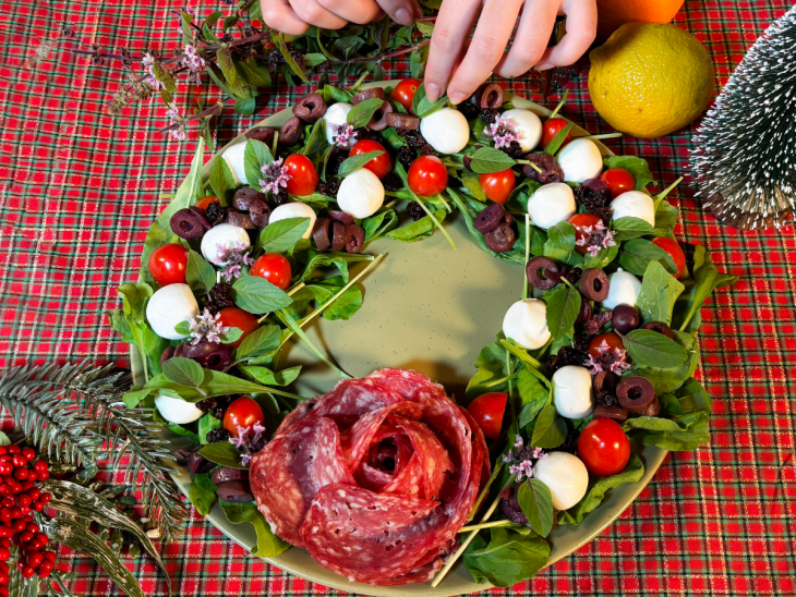 Folhas de manjericão finaliando a montagem da salada guirlanda.