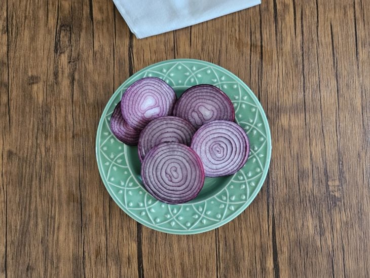 Um prato contendo cebolas roxas cortadas em rodelas.
