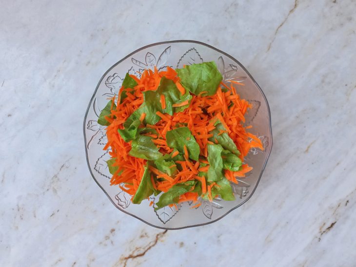 Cenoura ralada distribuída sobre a alface.