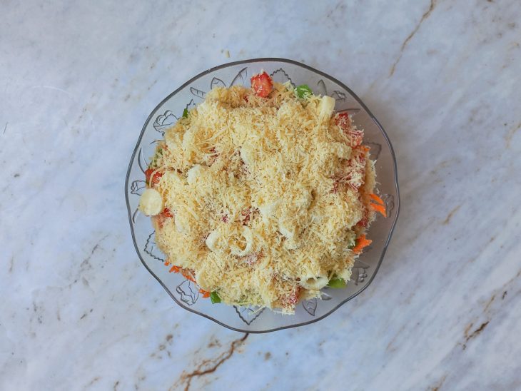 Queijo parmesão ralado polvilhado sobre os ingredientes.