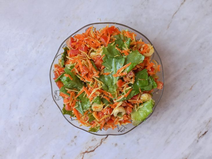 Molho sendo regado sobre a salada pronta para servir.
