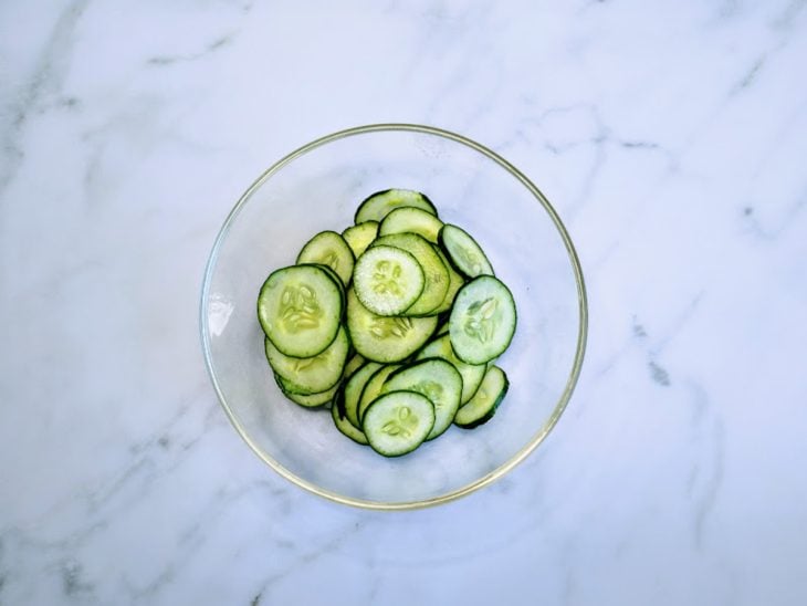 Um recipiente com pepino fatiado.