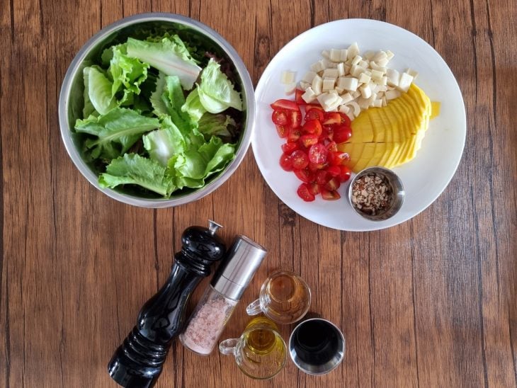 Ingredientes da salada tropical reunidos na bancada.
