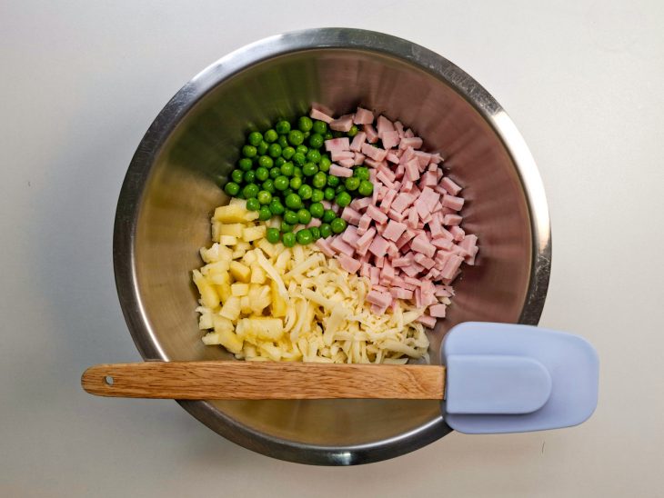 Abacaxi, o queijo prato, o peito de peru e as ervilhas na tigela.