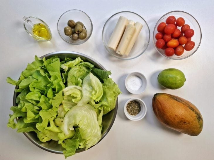 Ingredientes para a receita de salada tropical simples reunidos em uma bancada.