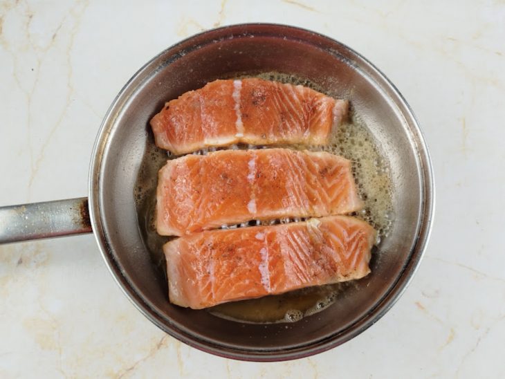 Salmão na frigideira com a manteiga.