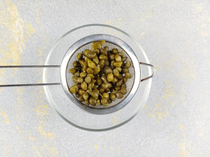 Alcaparras sendo dessalgadas em água.