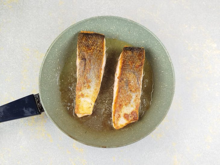 Salmão sendo virado para dourar o outro lado.