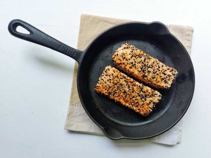 Uma frigidiera contendo fatias de salmão com crostas de gergelim.