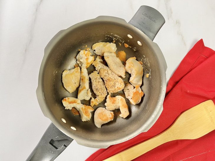 Uma panela de pressão com pedaços de frango.