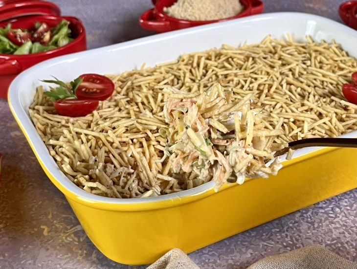Uma travessa contendo salpicão com batata palha.