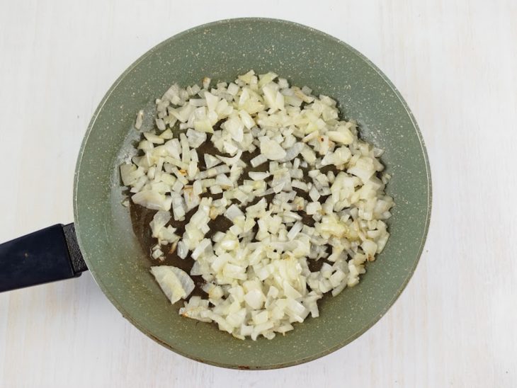 Alho e cebola refogados numa panela com azeite.