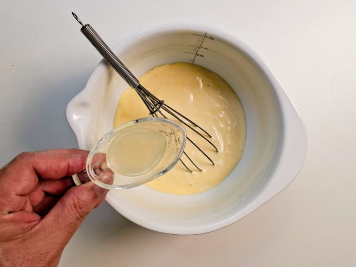 Suco do limão sendo adicionado a maionese.