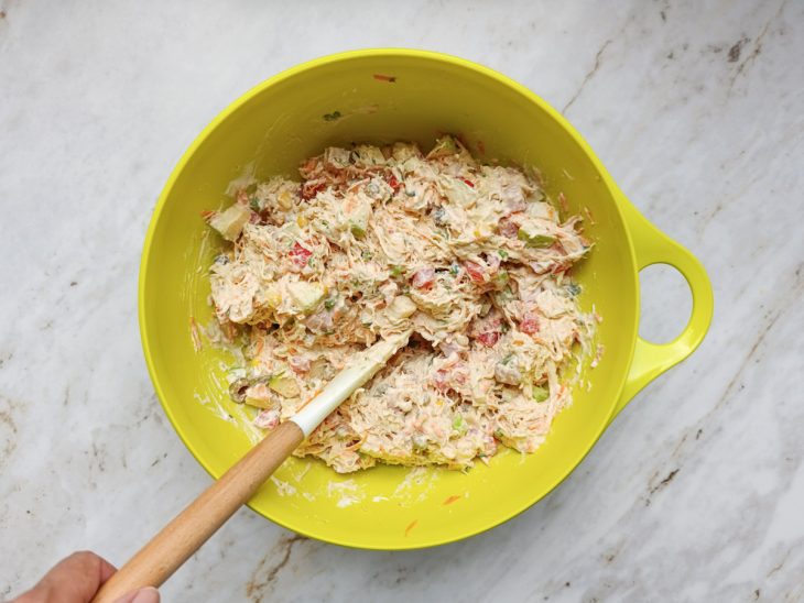 Molho incorporado na salada com o frango.
