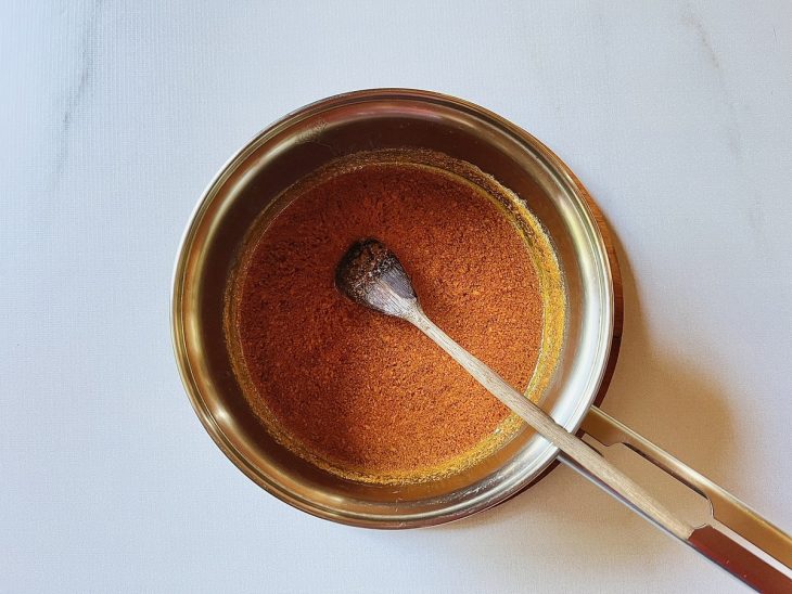 Uma panela com a manteiga derretida e colorau.