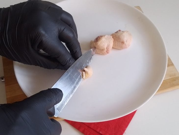 Um prato com sambiquiras de frango sendo cortadas.