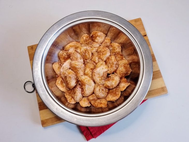 Um recipiente com sambiquiras de frango e temperos.