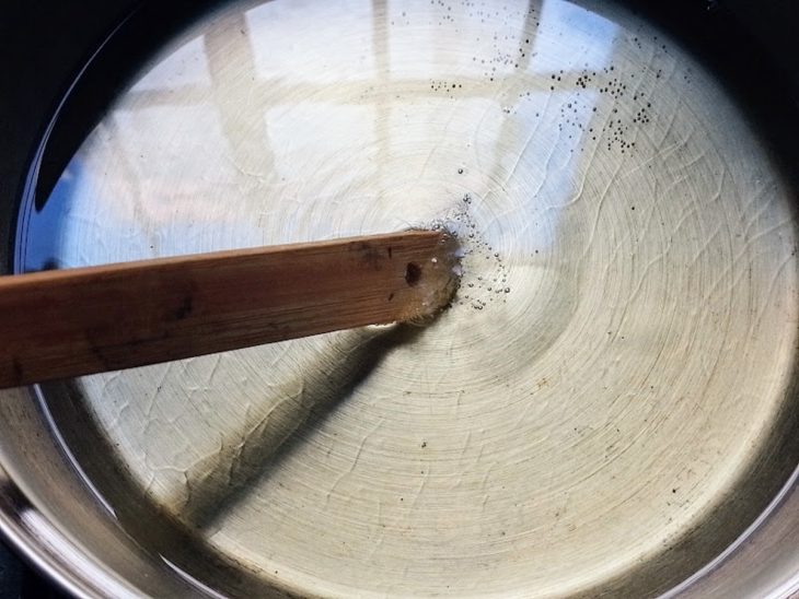 Uma panela com óleo quente e uma colher de pau.