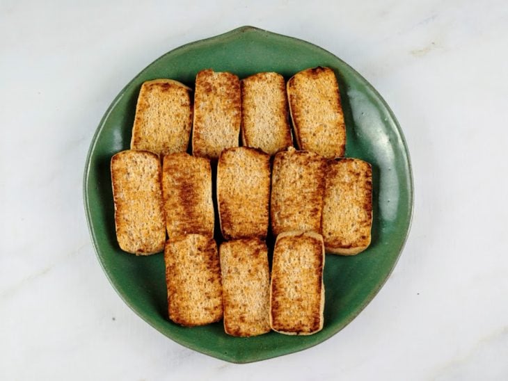 Um prato com bisnaguinhas tostadas.