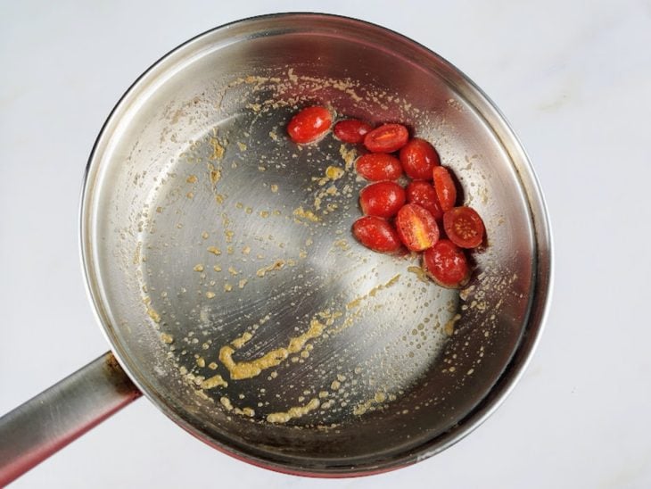 Uma frigideira com tomatinhos temperados.
