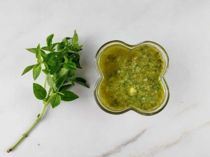 Um recipiente com molho pesto.