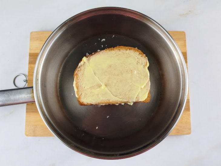 Uma frigideira com o sanduíche recheado.