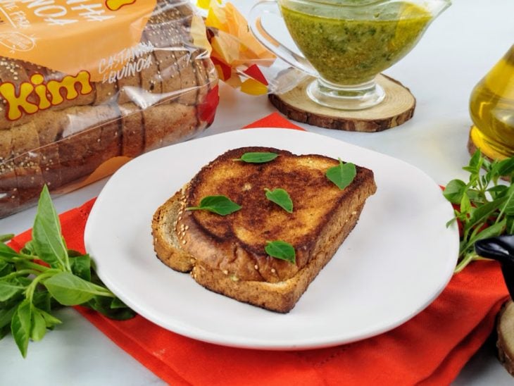 Um prato contendo sanduíche de frigideira com molho pesto e parmesão.