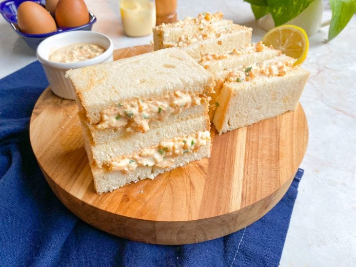 Uma tábua com sanduíche de ovo japonês.