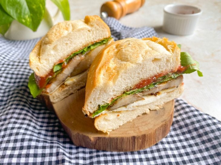 Sanduíche de panceta pronto para consumo cortado ao meio.
