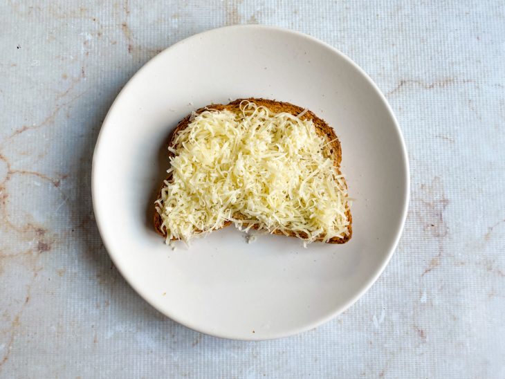 Queijo adicionado ao sanduíche.