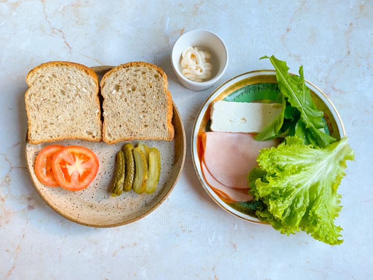 Ingredientes para preparar o sanduíche simples separados em uma bancada.