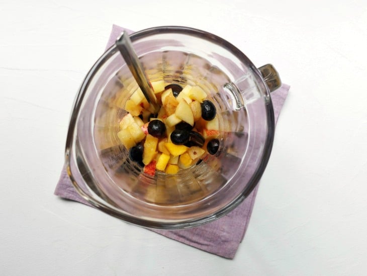 Uma jarra contendo as frutas e os sucos.