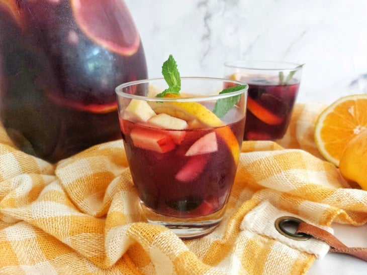 Uma bancada com garrafa e copos contendo sangria sem álcool.