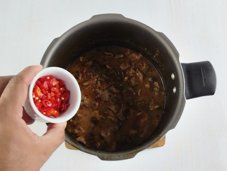 Pimenta-dedo-de-moça sendo picada para finalizar.