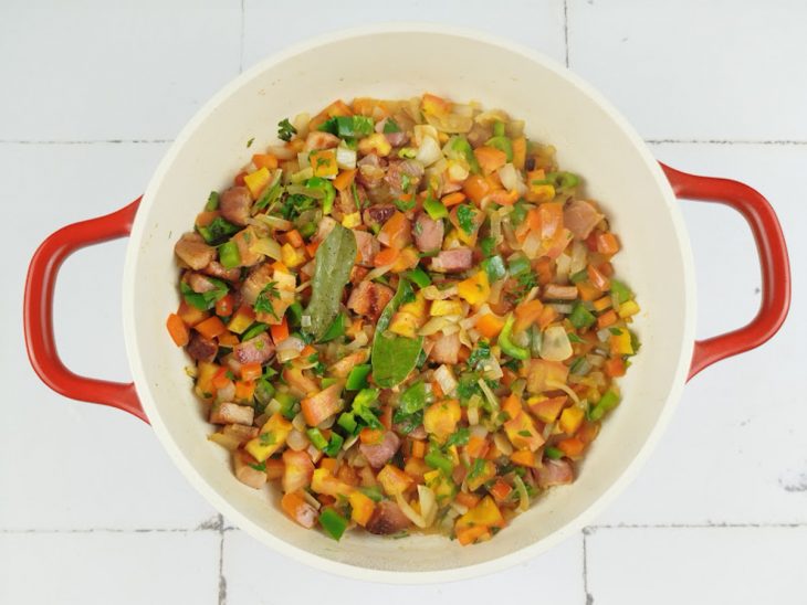 Ingredientes adicionados e refogados numa panela.