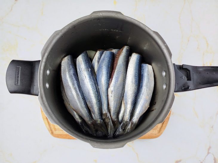 Sardinhas dispostas uma ao lado da outra na panela.
