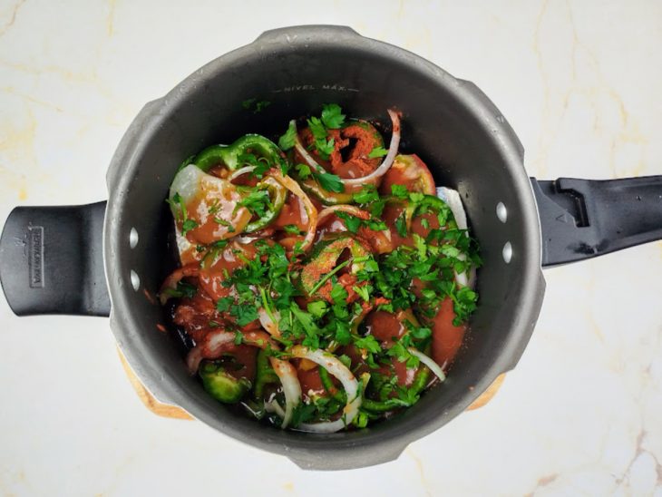 Colorau, cominho e molho de tomate na panela de pressão.