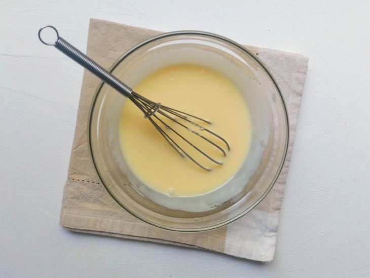 Leite condensado e manteiga misturados em uma tigela.