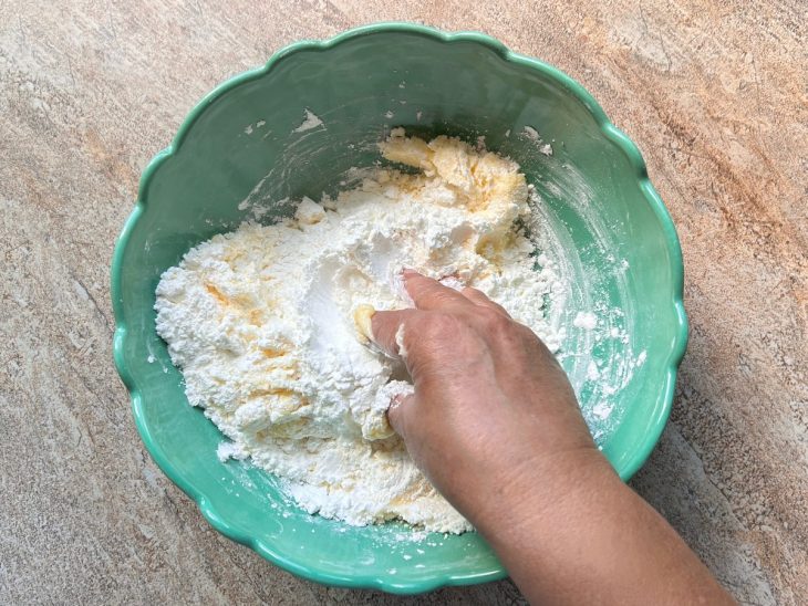 Ingredientes sendo misturados com as mãos.