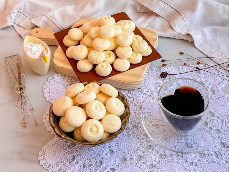 Sequilhos prontos, em pratos de servir, uma xícara de café acompanhando.