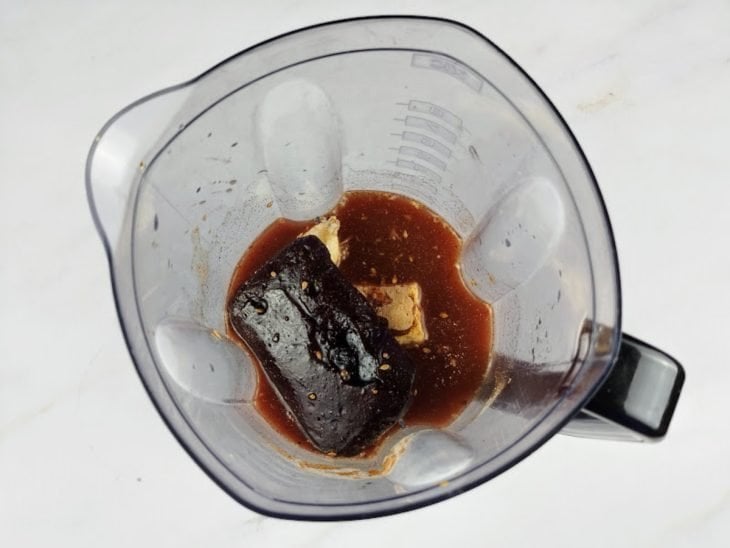 Chá gelado, polpa de açaí, banana, guaraná em pó, chia e mel misturados em um liquidificador.
