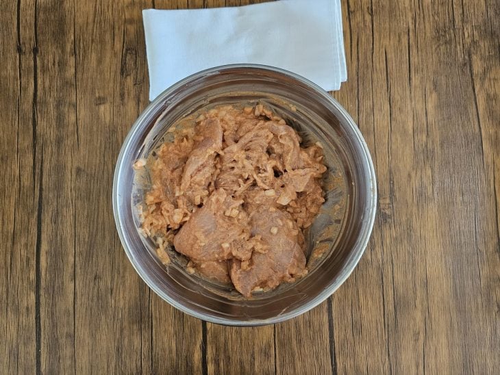 Uma tigela com frango e temperos.