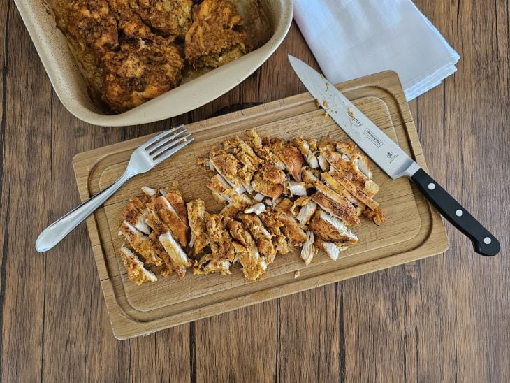 Uma tábua com frango fatiado.