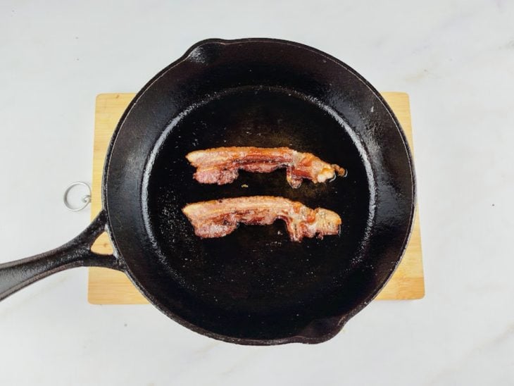 Fatias de bacon em uma frigideira.