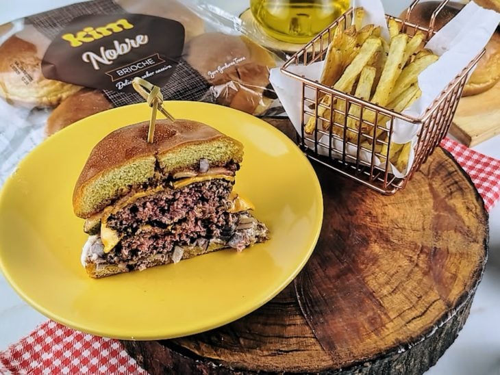 Smash burguer pronto para consumo e acompanhado por batatas fritas.