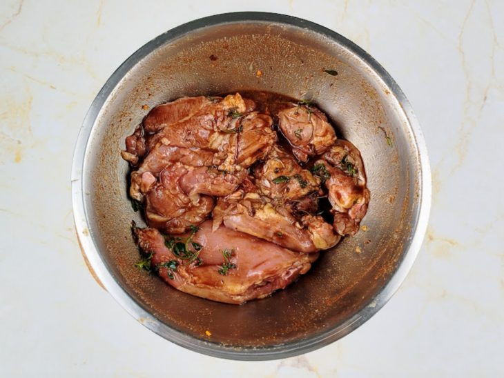sobrecoxa de frango marinando em temperos.