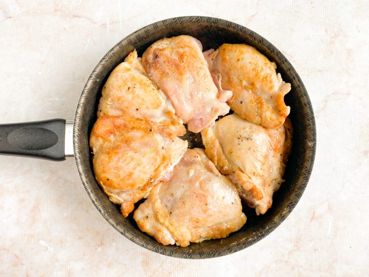 Sobrecoxas temperadas selando na frigideira com manteiga.